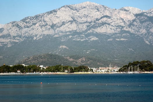 Nice view of Kemer beach with sand and mountains. Beautiful harbor near the sandy beach.