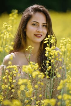 Portrait of a beautiful young woman surrounded by canola flowers.