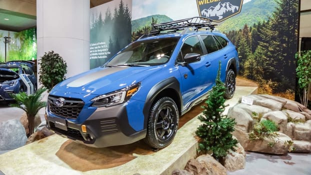 Crowds looking at new car models at Auto show. Subaru outback car on display. National Canadian Auto Show with many car brands. Toronto ON Canada Feb 19, 2023
