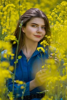 Portrait of a beautiful young woman surrounded by canola flowers.