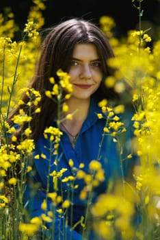 Portrait of a beautiful young woman surrounded by canola flowers.