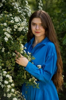 Portrait of a beautiful young woman surrounded by white small flowers.