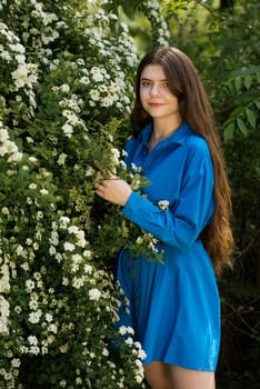 Portrait of a beautiful young woman surrounded by white small flowers.