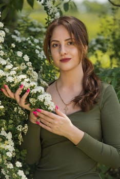 Portrait of a beautiful young woman surrounded by white small flowers.