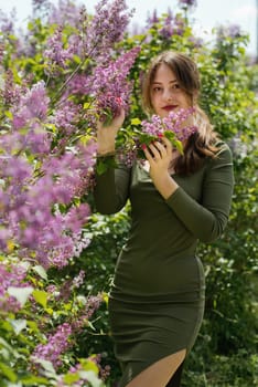 Beautiful young woman surrounded by lilac flowers.