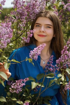 Portrait of a young woman in lilac flowers.