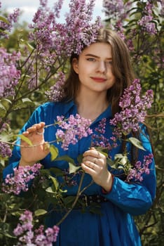 Portrait of a young woman in lilac flowers.