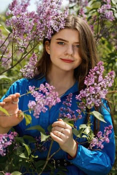 Portrait of a young woman in lilac flowers.