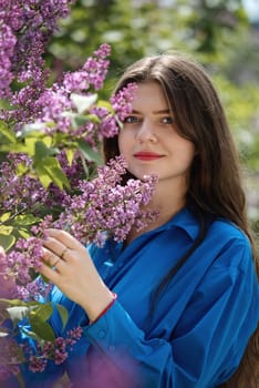 Portrait of a young woman in lilac flowers. Portrait of a young woman in lilac flowers. Spring blossom.