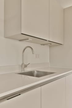 a kitchen with white cabinets and stainless sink fauced on the counter top in front of the dishwasher