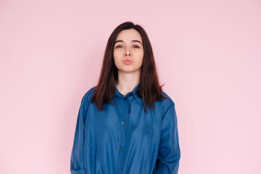 Radiant Elegance: Stunning Portrait of a Gorgeous Lady with Pouted Lips and a Playful Kiss, Wearing a Stylish Smart Casual Shirt, Isolated on a Captivating Pink Background.