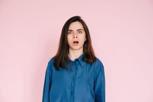 Stunning Portrait of a Speechless Woman in Utter Shock, Wide Open Mouth, Expressing Unbelievable Surprise - Isolated on Vibrant Pink Background.