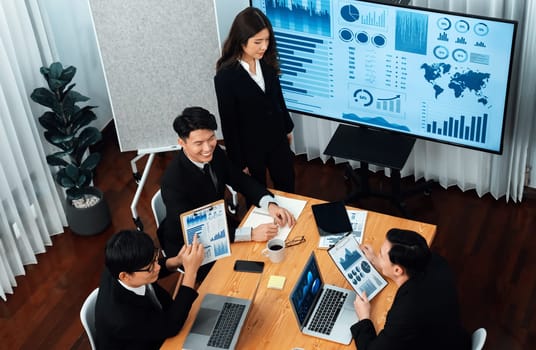 Top widen view of confidence of company presentation on financial analyzed by business intelligence in dashboard report with businesspeople in boardroom meeting to promote harmony in workplace concept