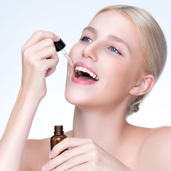 Closeup personable portrait of beautiful woman applying essential oil bottle for skincare product. Cannabis extracted CBD oil dropper for treatment and cannabinoids concept in isolated background.