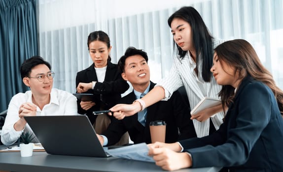 Harmony in office concept as business people analyzing dashboard paper together in workplace. Young colleagues give ideas at manager desk for discussion or strategy planning about project.