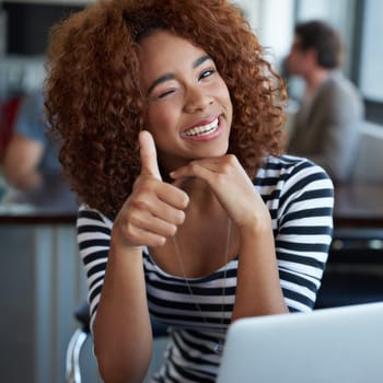 My work makes me happy. a young businesswoman using wireless technology in an office