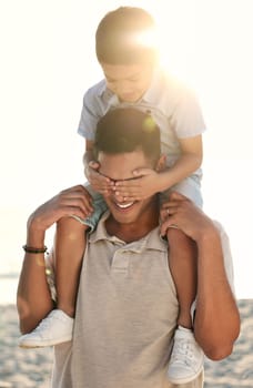 Beach, travel and child on shoulder of father with hands cover eyes for surprise game, quality time and playing. Family, love and happy boy with dad by ocean bond on adventure, holiday and vacation.