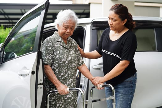 Caregiver help Asian elderly woman disability patient get in her car, medical concept.