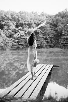 monochrome photo of a woman resting on a lake in the countryside in a long summer dress. High quality photo