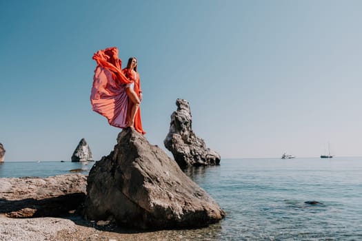 Woman travel sea. Happy tourist taking picture outdoors for memories. Woman traveler looks at the edge of the cliff on the sea bay of mountains, sharing travel adventure journey.