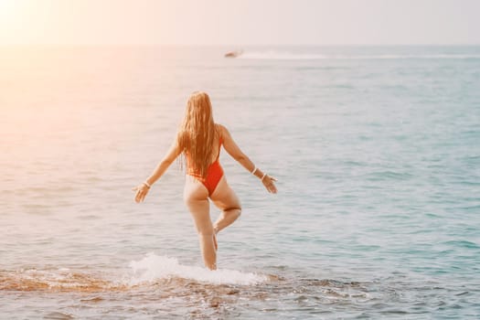 Woman sea yoga. Back view of free calm happy satisfied woman with long hair standing on top rock with yoga position against of sky by the sea. Healthy lifestyle outdoors in nature, fitness concept.