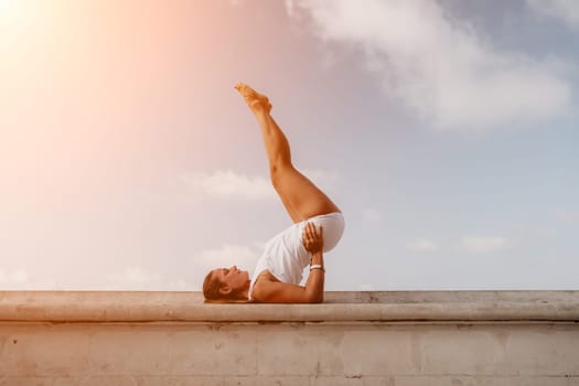 Fitness woman sea. Outdoor workout on yoga mat in park near to ocean beach. Female fitness pilates yoga routine concept. Healthy lifestyle. Happy fit woman exercising with rubber band in park.