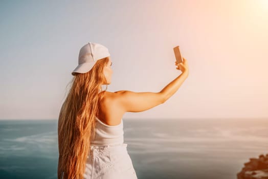 Woman travel sea. Young Happy woman in a long red dress posing on a beach near the sea on background of volcanic rocks, like in Iceland, sharing travel adventure journey