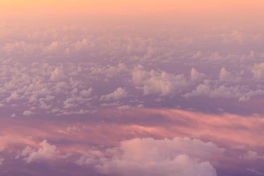 Looking down on pink haze over puffy white clouds at high elevation. High quality photo