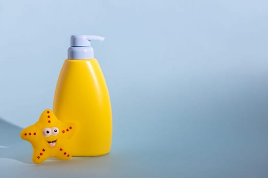 Yellow layout of a children's cosmetic product with a place for a logo and funny rubber toy. Baby shampoo, shower gel or body lotion. Space for text.
