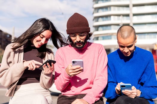 three young adults using mobile phones at city, concept of modern urban lifestyle and technology of communication