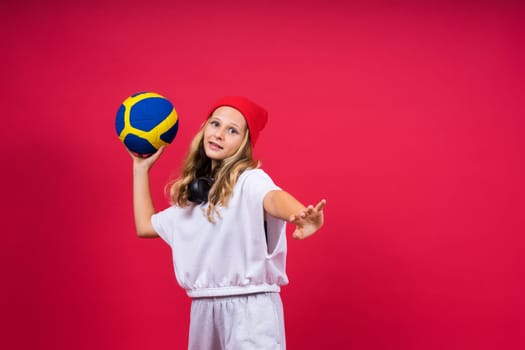 Portrait of cute eight year old girl in volleyball outfit isolated on a red yellow background