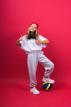 Portrait of cute eight year old girl in volleyball outfit isolated on a red yellow background