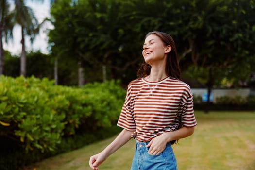 woman relax walk smiling fashion beauty lifestyle freedom bali nature striped outdoor active grass t-shirt beautiful summer park exercise sunny joy