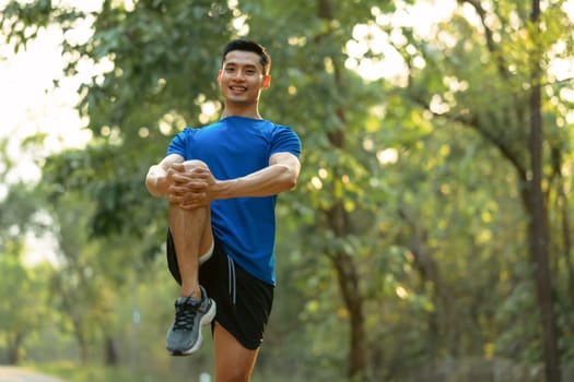 Handsome sportsman stretching his muscular before running in the morning. Fitness, sport and healthy lifestyle concept.