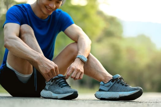 Male athlete tying shoelace get ready to running workout. Healthy lifestyle and wellness concept.