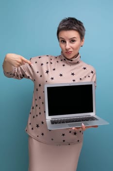 young looking business woman with gray streaked short hair demonstrates blank screen for promotional offer.