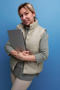 young blondie business woman with a laptop in her hands on a blue background.