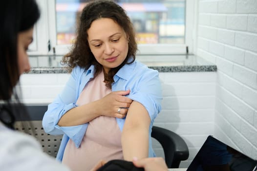 Pregnant woman visits obstetrician-gynecologist for regular check-up during pregnancy in gynecological clinic. Blood pressure measurement to prevent eclampsia. Pregnancy-induced Hypertension concept