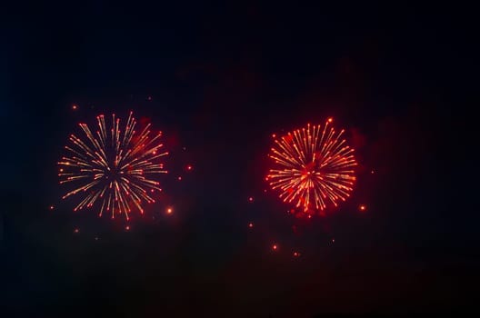 Two red fireworks in night sky.