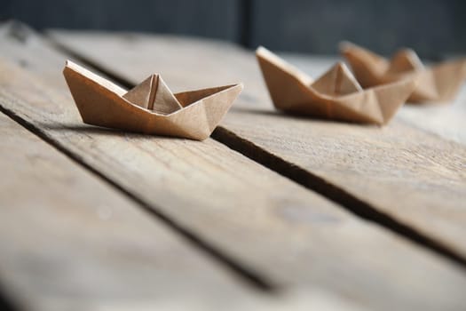 Paper boats on a vintage background. Origami paper boat.