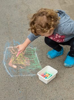 Children draw with chalk on the pavement. Selective focus. Kid.