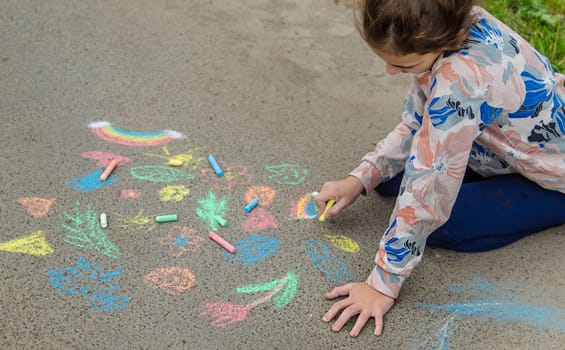 Children draw with chalk on the pavement. Selective focus. Kid.