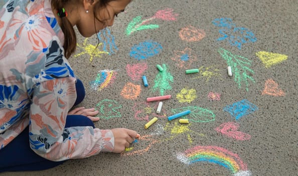 Children draw with chalk on the pavement. Selective focus. Kid.