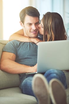 Romance and relaxation. a young couple using a laptop at home