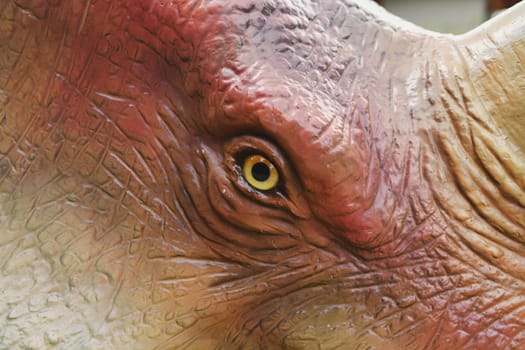Dinosaur eye pupil close up yellow eyes.