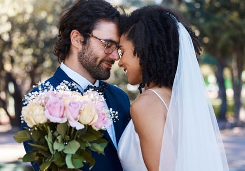 Married couple, flower and forehead with smile for wedding, marriage or loving commitment in the park. Happy groom and bride smiling in happiness for honeymoon, romance and embracing relationship.