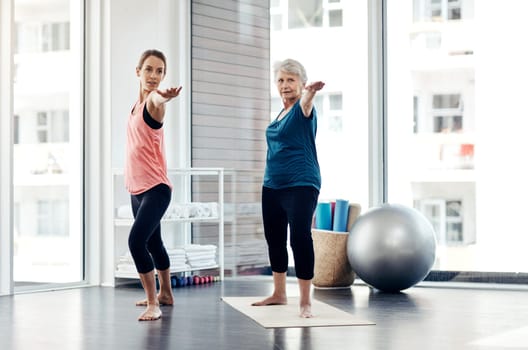 Yoga strengthens the body. a fitness instructor helping a senior woman during a yoga class