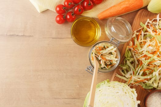 Cabbage lies on a wooden board with carrots, onions, herbs and cherry tomatoes. Preparing to cook cabbage dishes. copy space