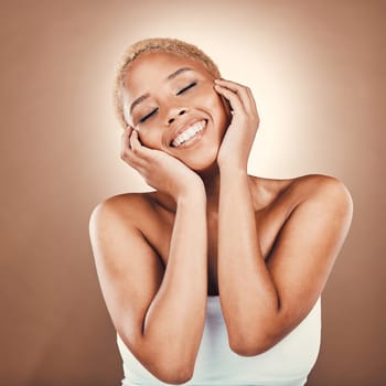 Black woman, hands on face and beauty smile on a brown background for dermatology cosmetics. Happy aesthetic model person in studio for skincare, self care and facial glow with clean and healthy skin.