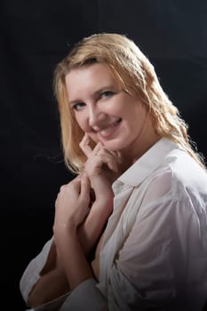 Portrait of beautiful sexy skinny girl with wet long blonde hair in dark hall. Female Model woman posing with water on a black background in the studio